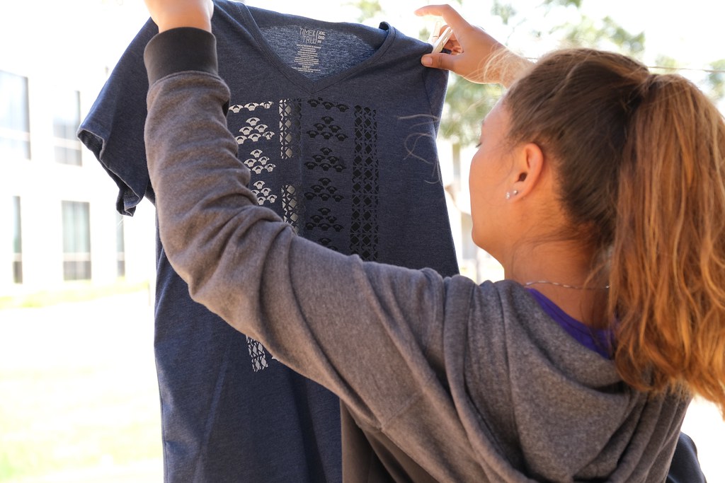 Person holding up and inspecting a printed shirt